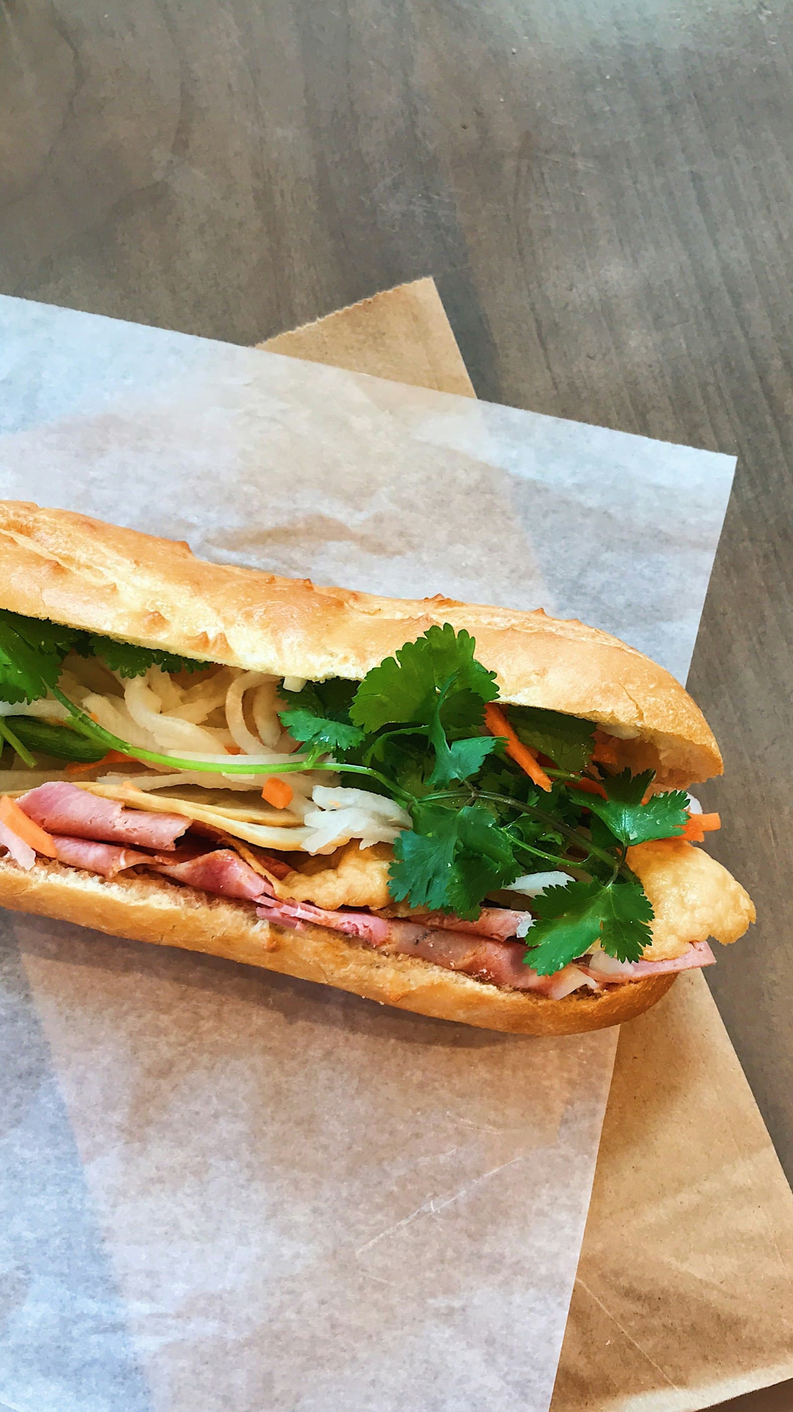 Frisch belegtes Bánh Mì mit Koriander, Pickles und knusprigem Baguette